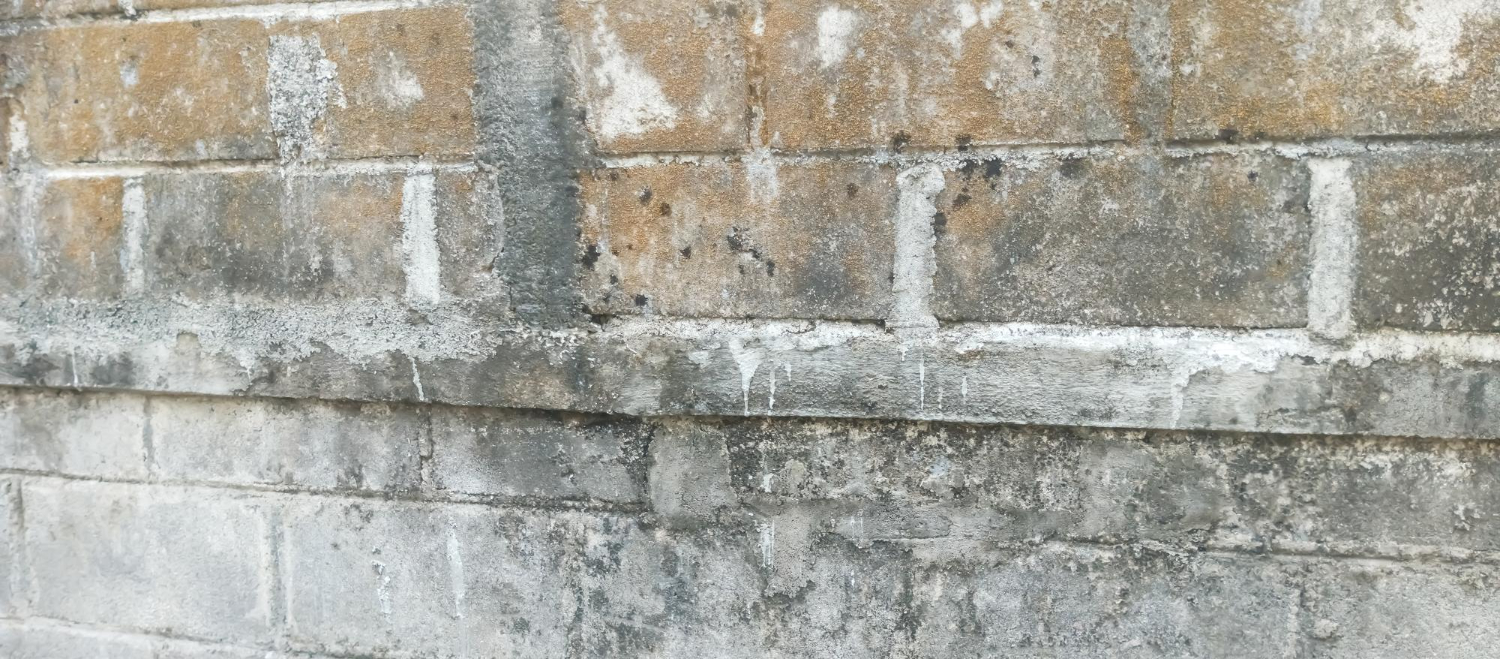 Weathered older stone and block wall with worn mortar joints